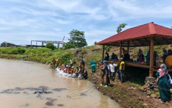 Dinas Perikanan Tebar Ribuan Benih Ikan Nila di Embung Senutuk, Warga Antusias Ikut Berpartisipasi