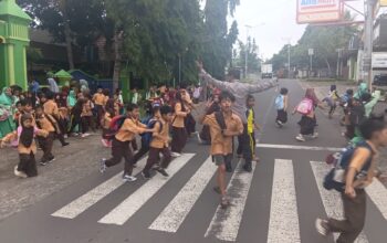 Personel Polsek Suela Atur Lalu Lintas di Depan SDN 02 Suela, Bantu Pelajar Menyeberang